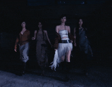 a group of women are walking in the dark