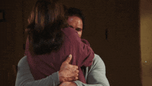 a man and woman hugging each other with the man giving the woman a thumbs up