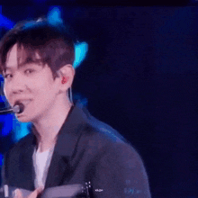 a close up of a person 's face while holding a microphone .