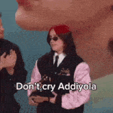 a woman in a pink jacket is holding a trophy and says do n't cry addiyola
