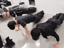 three men are doing push ups in front of a sign that says labels & tea