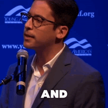 a man in a suit and glasses stands in front of a microphone and the word responsibility is above him