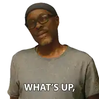 a man wearing glasses and a gray shirt says what 's up