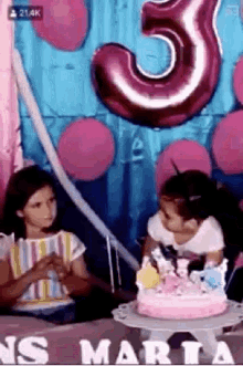 a little girl is blowing out a candle on her birthday cake .