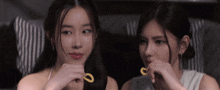 two women are eating french fries and one has a ring in her finger