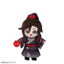 a stuffed doll is holding a red apple with chinese writing on it