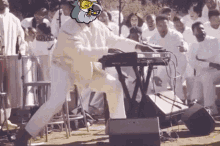 a man is playing a keyboard in front of a crowd of people