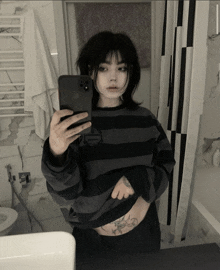 a woman taking a selfie with her phone in front of a mirror