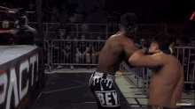 two wrestlers are fighting in a ring with a sign that says impact on it
