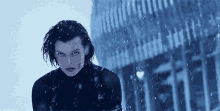 a woman is standing in the snow looking at the camera .