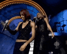 a couple of women dancing on a stage with a cbc logo in the background