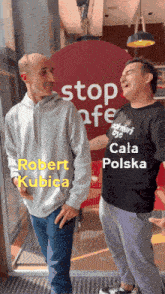 two men stand in front of a sign that says stop afe