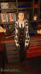 a man in a hat and scarf is standing in front of a bookshelf with the name joetastic on the bottom