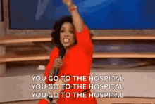 a woman in a red dress is holding a microphone and says you go to the hospital