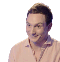a man wearing a pink shirt is smiling and looking to the side