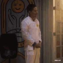 a man standing in front of a wall with a smiley face on it