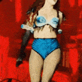 a woman in a blue bra and blue shorts is dancing on a stage
