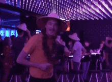 a man in a yellow shirt is holding a microphone