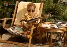 a little boy is sitting in a chair reading a magazine with the word passioni on the bottom right