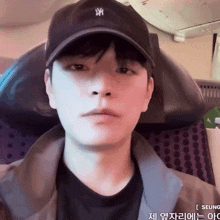 a young man wearing a black hat with the letter x on it