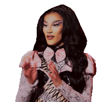 a woman wearing a zebra print top and a pink bow has her hands folded