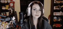 a woman wearing headphones is sitting in front of a microphone ..