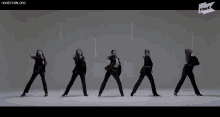 a group of women in suits are dancing in front of a sign that says honeycam.org
