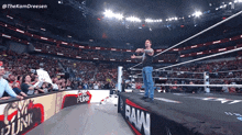 a wrestler stands on the edge of a wrestling ring with the word raw on the side