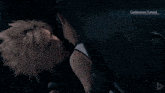 a man and a woman are looking at each other in a dark room