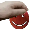 a hand is holding a red apple with a smiling face on it .