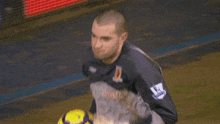 a man in a lottosport jersey holds a soccer ball in his hands