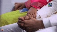 a person holding another person 's hand with a sony logo on the bottom right