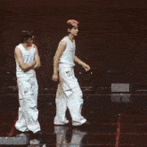 three men are walking on a stage holding hands .