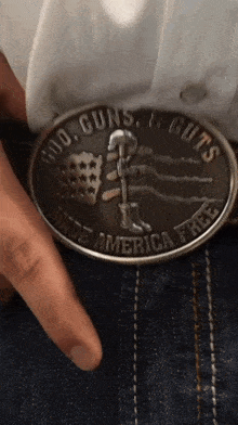 a belt buckle that says cold guns & guts made america free