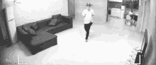 a man is running in a living room with a couch and television .