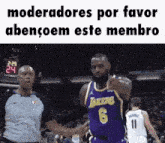 a basketball player in a lakers jersey is pointing at a referee