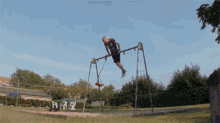 a man swings on a swing set in a park