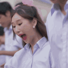 a girl with a pink bow on her head is making a funny face