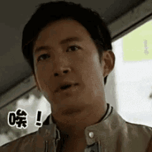 a man in a leather jacket is making a funny face while looking at the camera .
