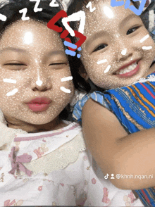 two little girls with hearts on their faces and the hashtag khnh.ngan.ni on the bottom