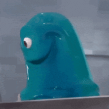 a blue monster with a big eye is sitting on a table .