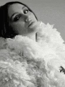 a black and white photo of a woman in a white fur coat