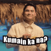 a man is smiling and holding a drink with kumain ka na written on the bottom