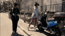 a blue scooter with the number 8 on the back is parked on the sidewalk