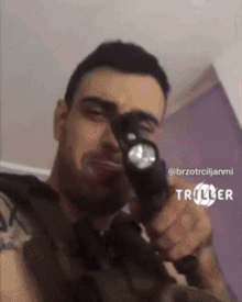 a man is holding a flashlight in his hand and taking a picture of himself .