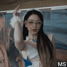 a woman wearing glasses and a headband with the letters ms on the bottom right