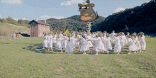 a group of women are dancing in a field with a cartoon mouse flying in the background