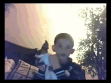 a boy is holding a small dog in his arms and the dog is wearing a shirt that says ' a ' on it