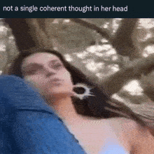 a woman is laying in a hammock with trees in the background and a single coherent thought in her head .