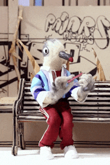 a stuffed bird is sitting on a bench in front of a sign that says padre